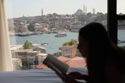 a woman looking out of a window at a river at Union Hotel Karaköy in Istanbul