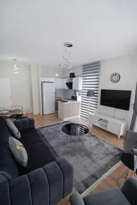 a living room with a blue couch and a kitchen at King Suite TH28 in Esenyurt