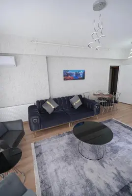 a living room with a blue couch and a table at King Suite TH28 in Esenyurt