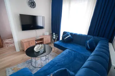 a living room with a blue couch and a tv at Classic Suite TS33 in Esenyurt