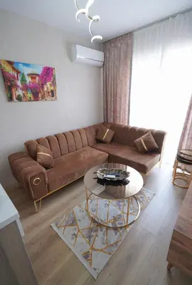 a living room with a brown couch and a table at Classic Suite TS22 in Esenyurt
