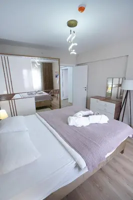 a white bedroom with a large bed and a mirror at King Suite OJ9 in Esenyurt