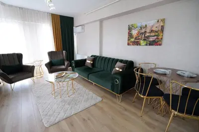 a living room with a green couch and a table at King Suite OJ9 in Esenyurt