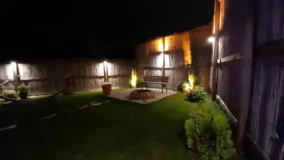 a backyard at night with a bench and lights at UĞURLUBUNGALOV in Sapanca