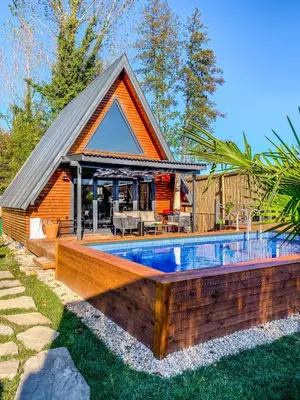 a house with a swimming pool in front of a house at UĞURLUBUNGALOV in Sapanca