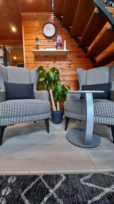 a living room with two chairs and a clock on a wall at UĞURLUBUNGALOV in Sapanca