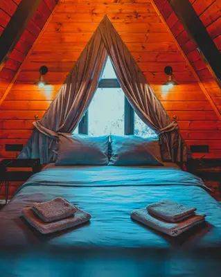 a bedroom with a bed with towels on it at UĞURLUBUNGALOV in Sapanca