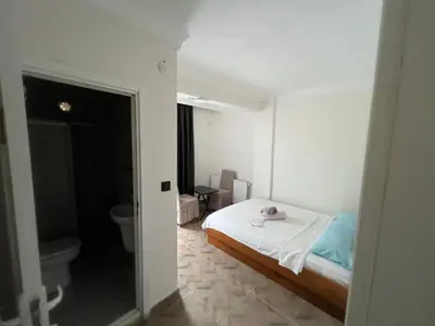 a small bedroom with a bed and a toilet at Airport See Viem Apartment in Arnavutköy