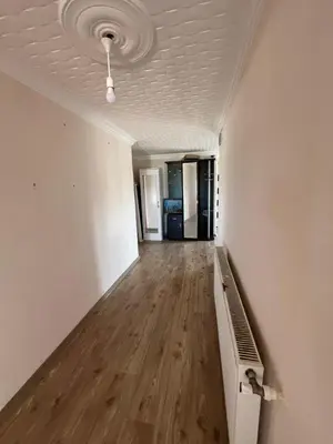 an empty room with white walls and a wooden floor at Airport See Viem Apartment in Arnavutköy