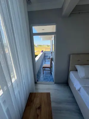 a bedroom with a bed and a chair and a window at Airport See Viem Apartment in Arnavutköy