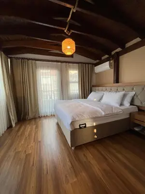 a bedroom with a large bed and wooden floors at PALMERA ART HOUSE in Istanbul