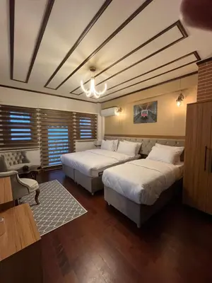 two beds in a room with wooden floors at PALMERA ART HOUSE in Istanbul