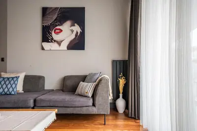 a living room with a couch and a picture of a woman at Benesta Guest Teori in Istanbul