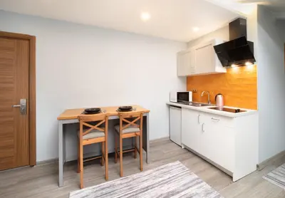 a kitchen with a small wooden table in a room at Park Çağlayan Hotel in Istanbul