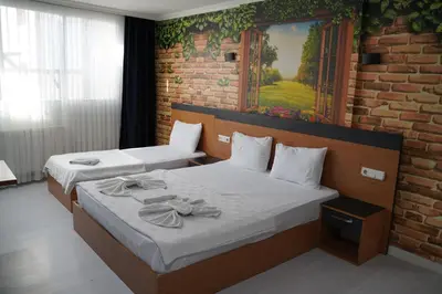 a bedroom with two beds and a brick wall at Heraldic Room Hotel in Esenyurt