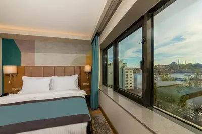 a hotel room with a bed and large windows at Csk The Halich Port İstanbul in Istanbul
