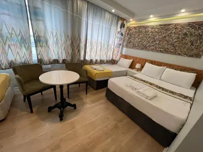 a room with two beds and a table and a couch at Rodin Hostel in Istanbul