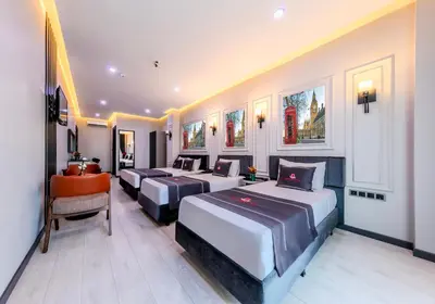 a hotel room with four beds and a chair at Intercity Hotel Istanbul Airport in Arnavutköy