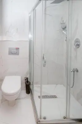 a white bathroom with a shower and a toilet at The Center Hotel in Istanbul