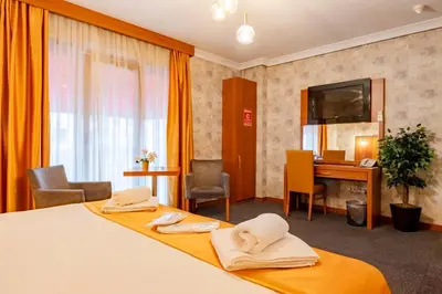 a hotel room with two beds and a desk at My Palace Residance in İçmeler