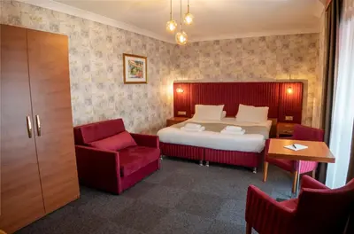 a hotel room with a bed and a red chair at My Palace Residance in İçmeler