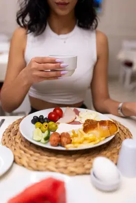 a woman sitting at a table with a plate of food at My Palace Residance in İçmeler
