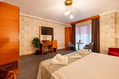 a hotel room with two beds and a desk at My Palace Residance in İçmeler