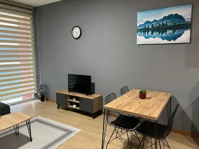 a living room with a table and a tv at Nur Sena's House in Istanbul