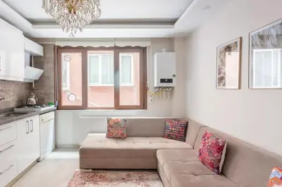 a living room with a couch and a kitchen at İstanbul'un merkezinde Cevahir AVM karşısı 1+1 yeni ev in Istanbul