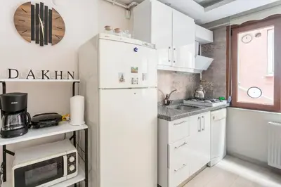 a kitchen with white cabinets and a refrigerator at İstanbul'un merkezinde Cevahir AVM karşısı 1+1 yeni ev in Istanbul