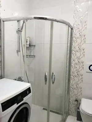 a shower in a bathroom with a washing machine at İstanbul'un merkezinde Cevahir AVM karşısı 1+1 yeni ev in Istanbul