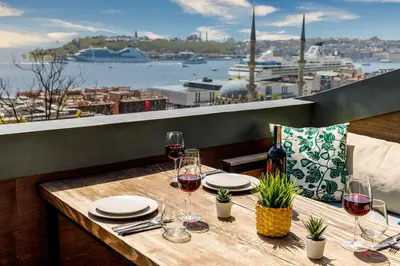 a wooden table with glasses of wine on a balcony at Monnas Bosphorus in Istanbul