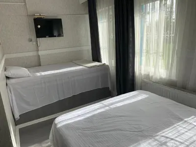 a small bedroom with two beds and a window at antik sofia hotel in Istanbul