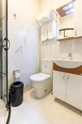 a white bathroom with a toilet and a sink at Valens Boutique Hotel in Istanbul