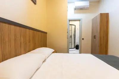 a bedroom with a large white bed with a wooden headboard at Valens Boutique Hotel in Istanbul