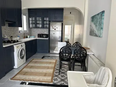 a kitchen with blue cabinets and a table and chairs at Center of city in Beşiktaş 2 plus 1 with 2 Bathroom and 3 Air Conditioner in Istanbul