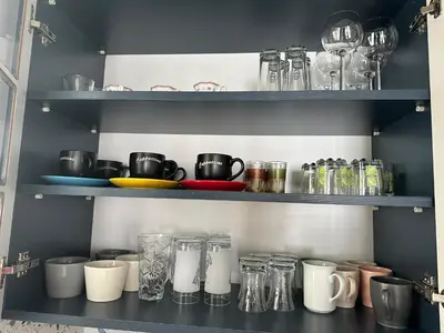 a shelf filled with glasses and other glass items at Center of city in Beşiktaş 2 plus 1 with 2 Bathroom and 3 Air Conditioner in Istanbul