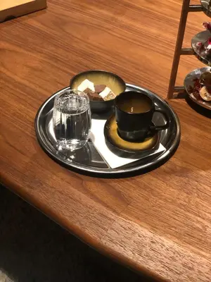 a plate with a cup of coffee and a glass on a table at The Mill Bomonti in Istanbul