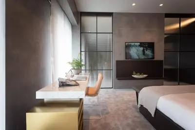 a bedroom with a bed and a desk and a bed and a room with at The Mill Bomonti in Istanbul
