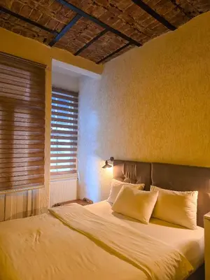 a bedroom with a bed with white sheets and a window at Karakoy Port House in Istanbul