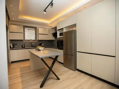 a kitchen with a table and a refrigerator at New Balturk Villas Sapanca in Sapanca