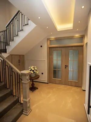a hallway with stairs and a door with a vase of flowers at New Balturk Villas Sapanca in Sapanca