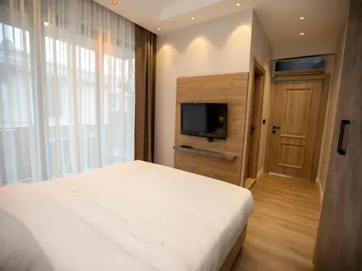 a bedroom with a white bed and a television at New Balturk Villas Sapanca in Sapanca