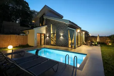a swimming pool in front of a house at night at New Balturk Villas Sapanca in Sapanca