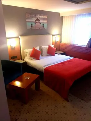 a hotel room with a bed and a red blanket at ZEO HOTEL merter in Istanbul