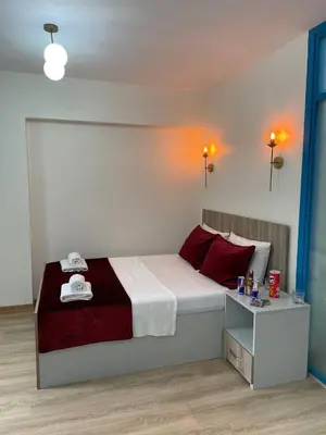 a bedroom with a bed with red pillows and a table at PANORAMA CITY SUITE in Istanbul