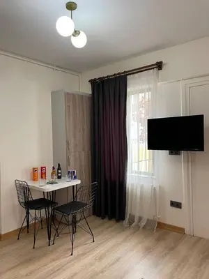 a living room with a table and chairs and a television at PANORAMA CITY SUITE in Istanbul