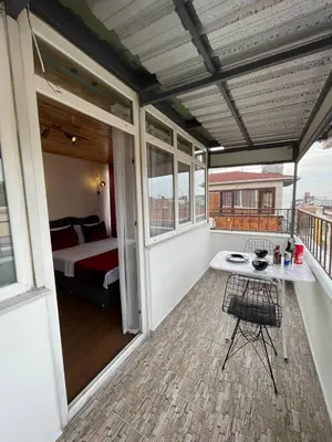 a room with a balcony with a bed and a table at PANORAMA CITY SUITE in Istanbul
