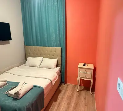 a small room with two beds and a night stand at Taksim Soushian Hotel in Istanbul