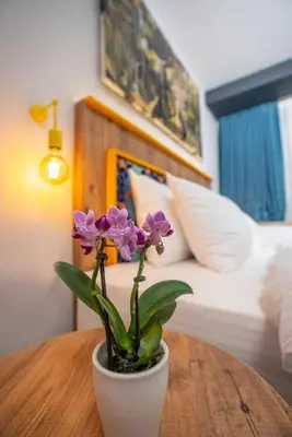 a vase with purple flowers sitting on a wooden table at The Gate Kadıköy Downtown in Istanbul
